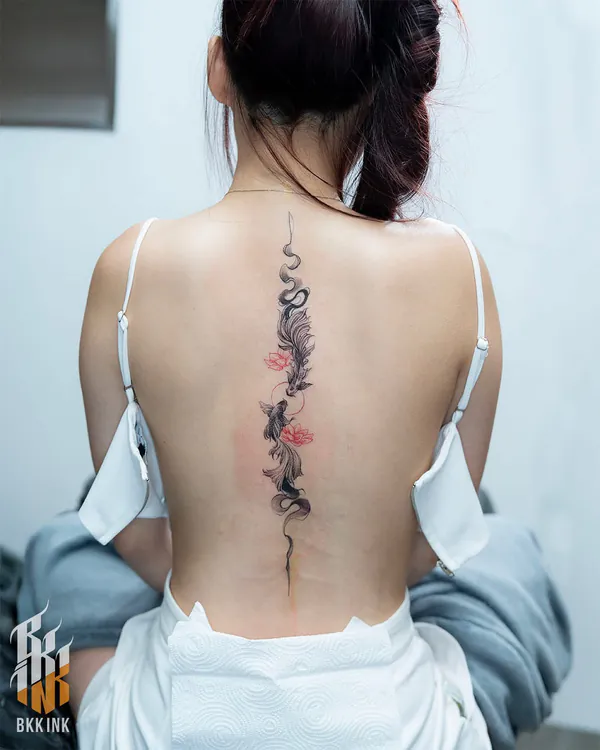 Koi fish and lotus spine feminine tattoo Bangkok