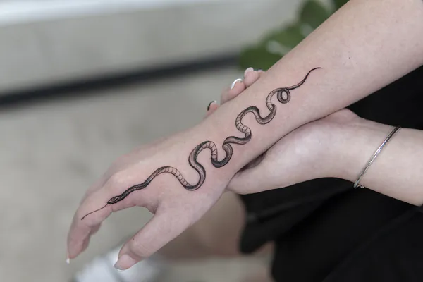 Realistic snake wrapping forearm feminine girly tattoo Bangkok