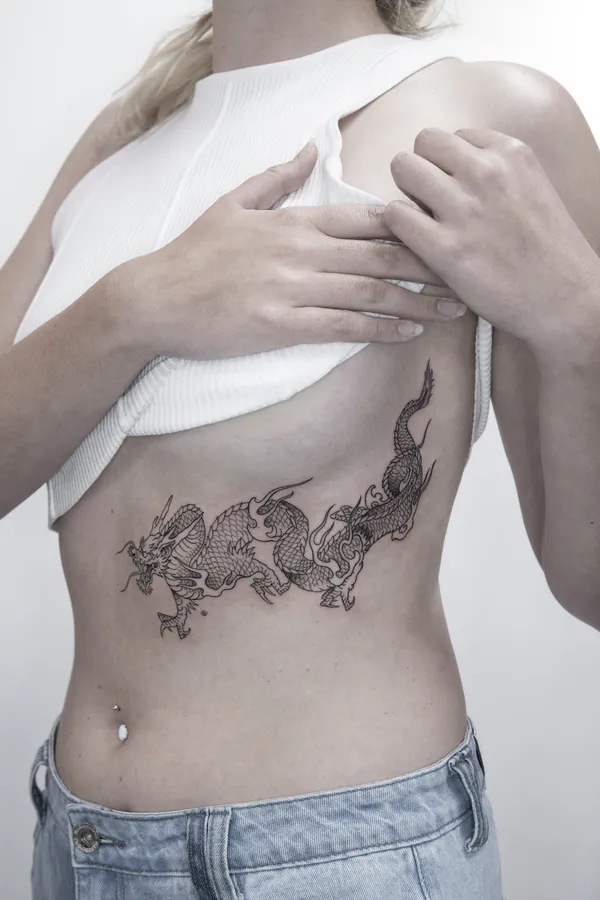 Chinese dragon linework ribs feminine girly tattoo Bangkok