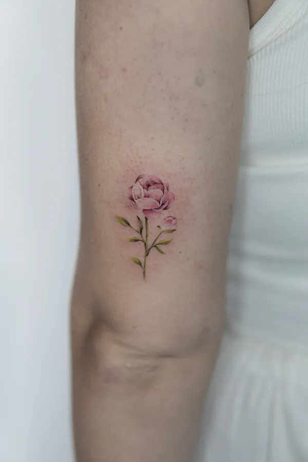 Small pink peony upper arm feminine tattoo Bangkok