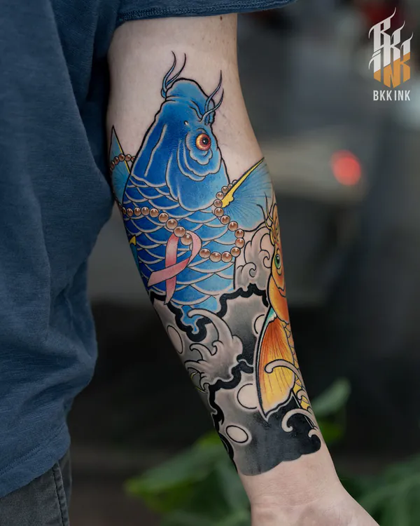 Horned blue creature and koi head forearm Japanese tattoo Bangkok