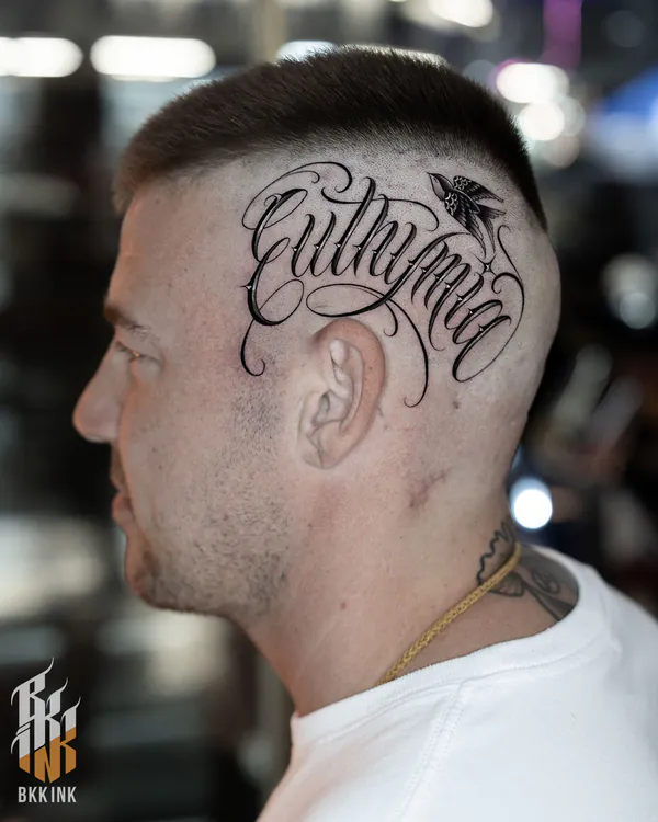 Cursive script back of head lettering tattoo Bangkok