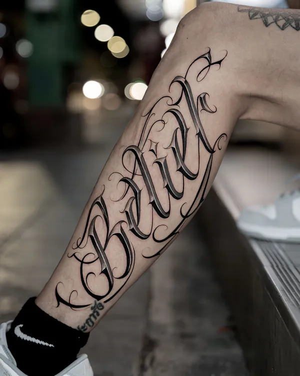 Bold blackletter word calf lettering tattoo Bangkok