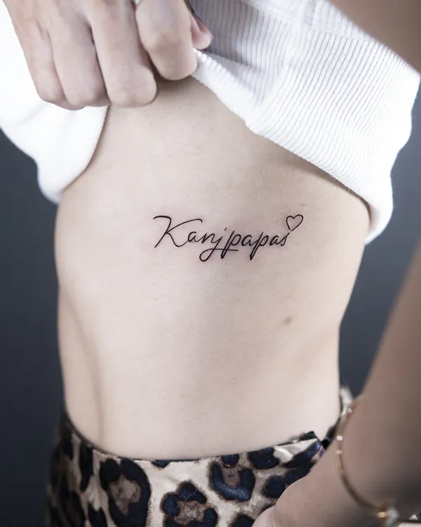 Fine cursive heart accent rib lettering tattoo Bangkok