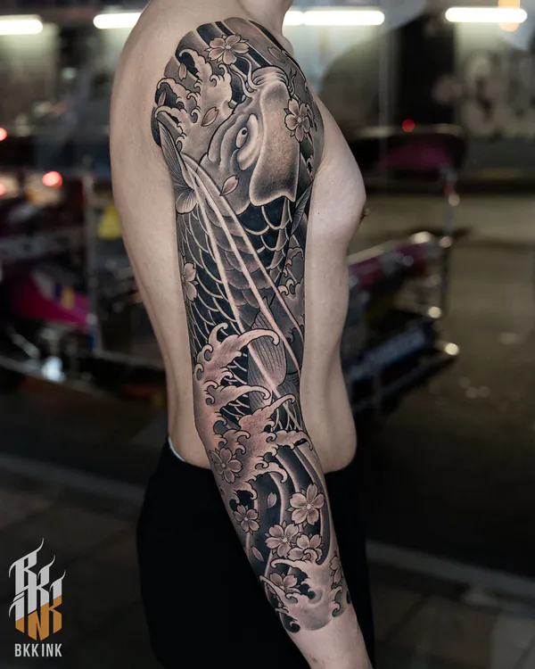 Black and grey koi swimming through waves sleeve tattoo Bangkok by Mhee