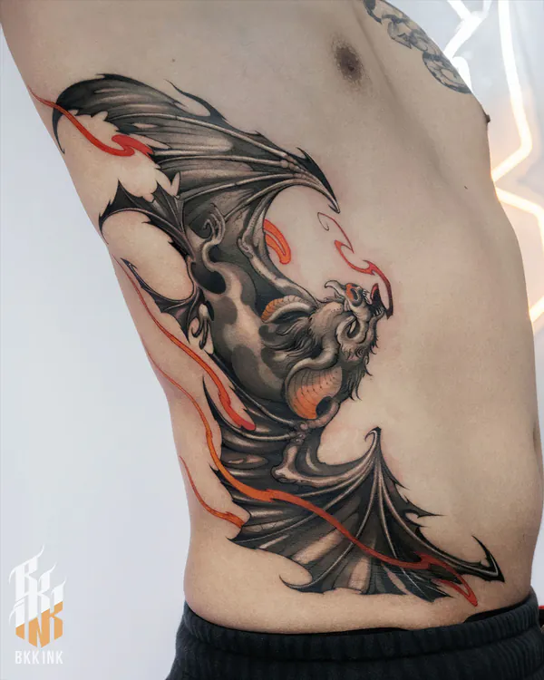 Black and grey bat with red flames ribs neo-traditional tattoo Bangkok