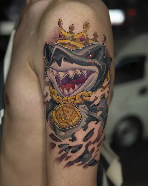 Shark wearing crown and gold chain upper arm new school tattoo Bangkok