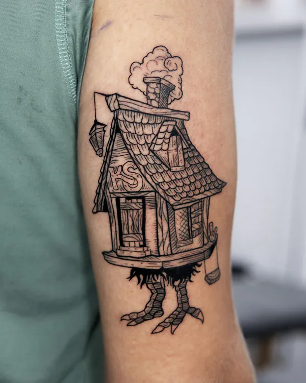 Haunted house on chicken legs upper arm new school tattoo Bangkok