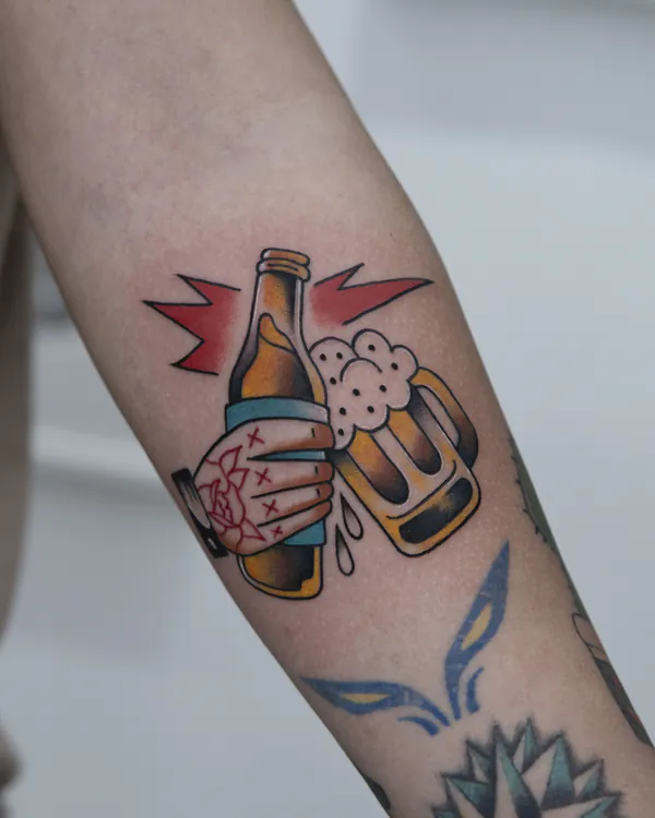 Hand toasting beer bottle and mug forearm old school tattoo Bangkok
