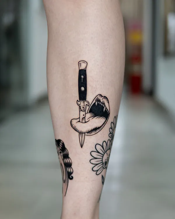 Dagger through mouth blackwork shin old school tattoo Bangkok