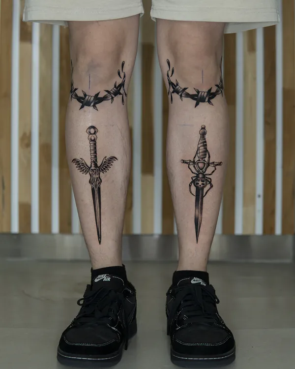 Matching daggers with barbed wire bands shins old school tattoo Bangkok