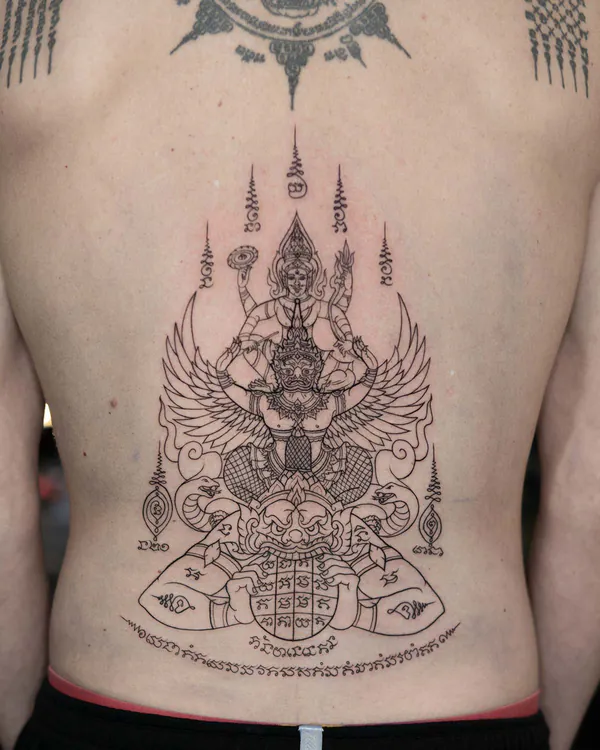 Garuda deity guardian face lower back Sak Yant tattoo Bangkok