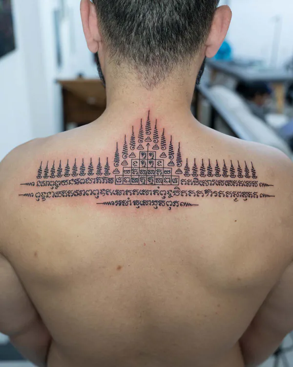 Sacred spires script upper back Sak Yant tattoo Bangkok