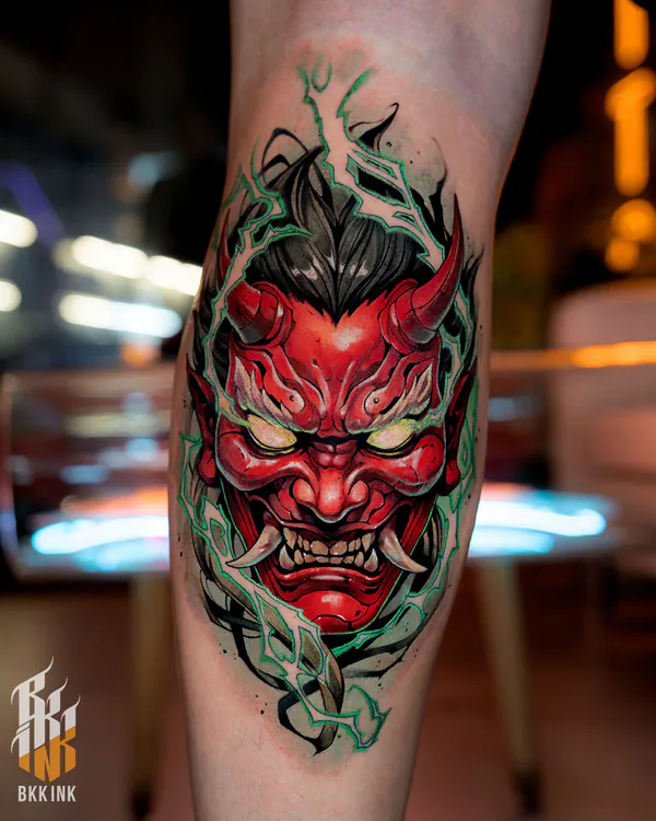 Red oni demon face with green flames calf tattoo Bangkok by Vay