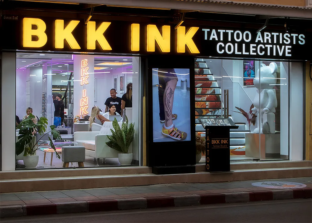BKK INK tattoo studio storefront at night on Khaosan Road Bangkok with illuminated sign